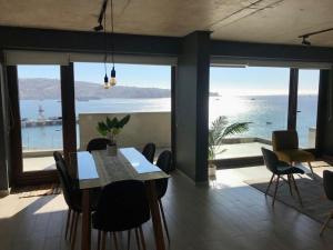 - une salle à manger avec une table et une vue sur l'océan dans l'établissement AMPLIO 4D3B Mejor ubicación Valparaíso Parking 6PAX Servicio HOM, à Valparaíso
