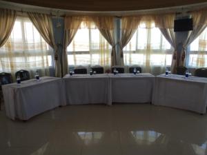 zestaw stołów w pokoju z oknami w obiekcie NEDLAND INN w mieście Konza
