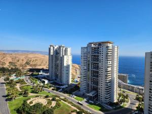 dos edificios de apartamentos altos junto al océano en Dúplex de Lujo en Concón con Terraza vista al mar Servicio HOM 0421, en Concón