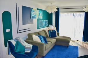 sala de estar con sofá y alfombra azul en Hemel Apartments- Riverside Retreat en Hemel Hempstead