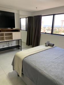 a bedroom with a bed and a flat screen tv at Inova Flat aconchego no Condominio Cosmopolitan in Palmas