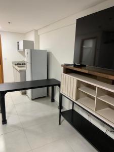 a kitchen with a black table and a refrigerator at Inova Flat aconchego no Condominio Cosmopolitan in Palmas