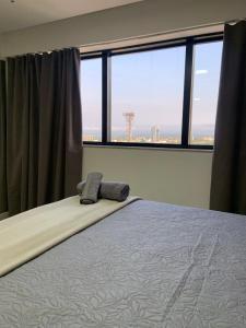 a bedroom with a bed and a large window at Inova Flat aconchego no Condominio Cosmopolitan in Palmas