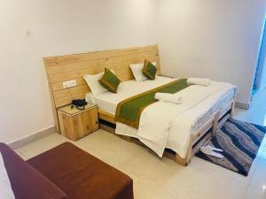 a bedroom with a large bed with a cat sitting on it at Hotel Badrinath Charan in Ghāstoli