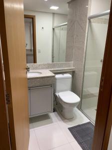 a bathroom with a toilet and a sink at Inova Flat aconchego no Condominio Cosmopolitan in Palmas