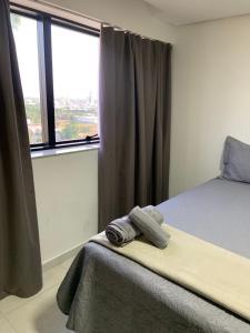 a bedroom with a bed and a large window at Inova Flat aconchego no Condominio Cosmopolitan in Palmas