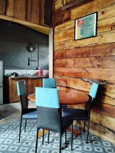 a dining room with a wooden wall with a table and chairs at hostal Coñaripe in Panguipulli