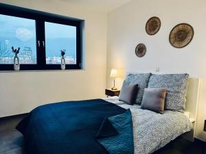 ein Schlafzimmer mit einem blauen Bett und einem Fenster in der Unterkunft FeWo Am Povelturm - mit Aufzug und großer Loggia in Nordhorn