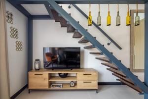 a living room with a staircase with a tv and a wooden cabinet at Frank Porter - Aria by Grovy in Dubai