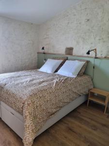 een slaapkamer met een groot bed met 2 kussens bij O Pressoir in Le Pellerin