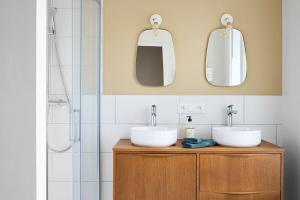 een badkamer met 2 wastafels en 2 spiegels bij Nouveau - Harmonia in Nantes