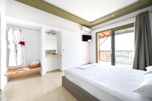 a bedroom with a large bed and a window at Makis Sea View Studios in Skiathos