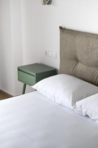 a bedroom with a bed with a green night stand at Makis Sea View Studios in Skiathos Town