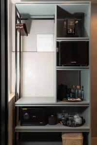 a kitchen cabinet with a microwave and a refrigerator at Domingo x Casa Norte in Birgu