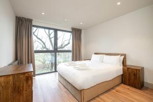 a bedroom with a large bed and a large window at The Sessile in London