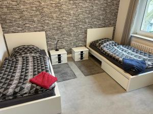 dwa łóżka w pokoju z ceglaną ścianą w obiekcie Apartment für Familien, Urlauber und Monteure w mieście Duisburg