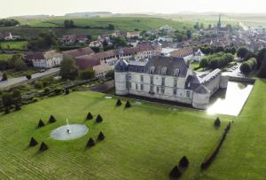 eine Luftansicht eines großen Gebäudes auf einem grünen Feld in der Unterkunft Le Château D'Etoges in Étoges