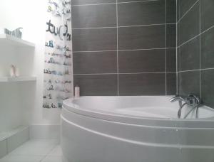 a white bath tub in a bathroom with a shower at Loft Biarritz proximité Mer et Golf in Biarritz