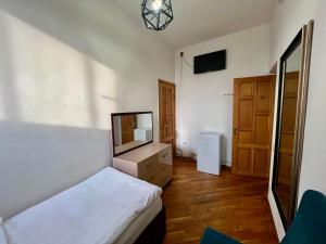 a bedroom with a bed and a dresser with a television at Family Hotel in Yerevan