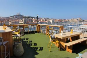 einen Balkon mit Tischen und Stühlen auf einem Kreuzfahrtschiff in der Unterkunft Hôtel Hermès in Marseille