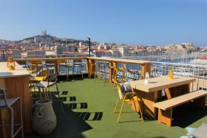 a balcony with tables and chairs on a cruise ship at Hôtel Hermès in Marseille