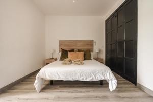 a bedroom with a large bed with two towels on it at Los Cardones Boutique Village in Playa de las Americas