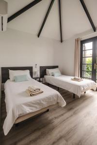 a white room with two beds and a window at Los Cardones Boutique Village in Playa de las Americas