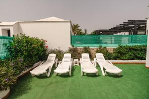 a group of lawn chairs sitting on the grass at Los Cardones Boutique Village in Playa de las Americas