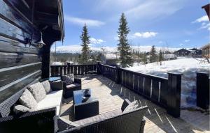 a patio with couches and chairs on a deck in the snow at Cozy Home In Trysil With Wifi in Trysil