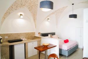 - une cuisine avec évier et un lit dans une chambre dans l'établissement Suite Votano 24 - RELAX nel CUORE ANTICO di CEGLIE, à Ceglie Messapica