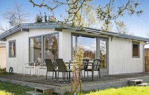 une maison avec une table et des chaises sur une terrasse dans l'établissement Awesome Home In Stubbekbing With 3 Bedrooms And Wifi, à Stubbekøbing