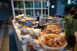 a buffet with pastries and other food on a table at Infinity Pool Ceylonz Suites KLCC in Kuala Lumpur