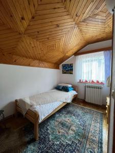 a bedroom with a bed and a wooden ceiling at Guesthouse Vratnik in Sarajevo