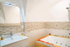 La salle de bains est pourvue d'une baignoire et d'un lavabo. dans l'établissement Suite Votano 24 - RELAX nel CUORE ANTICO di CEGLIE, à Ceglie Messapica