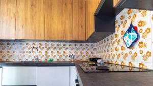 a kitchen with orange and white tiles on the wall at Panorama Blu in S'archittu Cuglieri