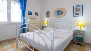 a bedroom with a white bed and a window at Panorama Blu in S'archittu Cuglieri