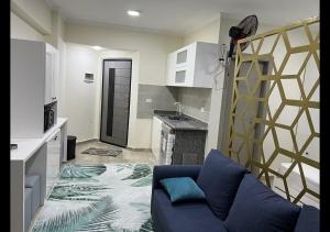 a living room with a blue couch and a kitchen at Princess resort in Hurghada