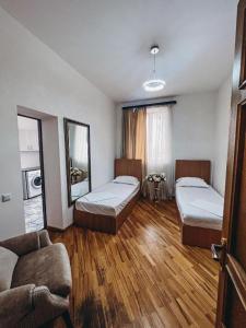 a living room with two beds and a couch at Family Hotel in Yerevan