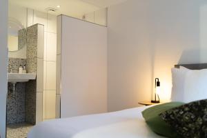 - une chambre avec un lit blanc et un lavabo dans l'établissement 't Achterhuis (2 persons), à Otterlo