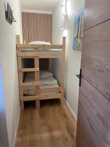 um beliche de madeira num quarto com piso de madeira em UN CHALET A LA MER em Saint-Cyprien