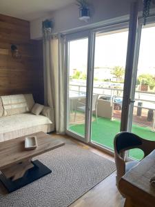 a living room with a couch and a table at UN CHALET A LA MER in Saint-Cyprien