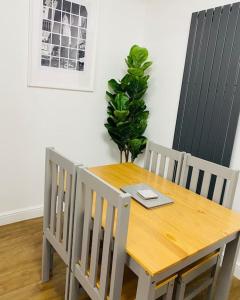 a wooden table with two chairs and a laptop on it at Colston House in Newport