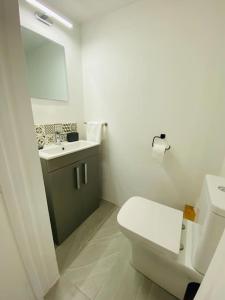 a white bathroom with a toilet and a sink at Colston House in Newport