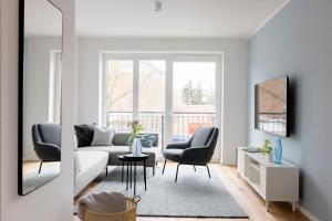 a living room with a couch and two chairs at Pier21 FINE LOFTS in Böhl