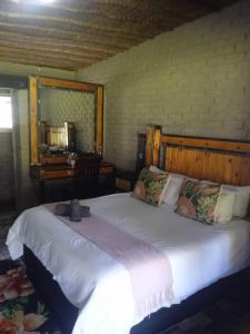ein Schlafzimmer mit einem großen weißen Bett in einem Zimmer in der Unterkunft Kameelboom Lodge in Vryburg