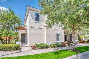 a white house with a tree in a yard at Roomy Town Home, Mickey-Themed Bedroom! #4BV550 in Kissimmee