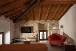 a living room with a red chair and a tv at Appartamenti La Grotta in Bardolino