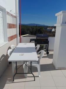 a white table and chairs on a balcony at Casa Paulinho in Portimão