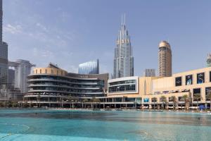 a large building with a swimming pool in front of a city at Frank Porter - Mon Reve in Dubai