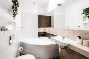a bathroom with a tub and a sink and a toilet at Fully-furnished Apartment with Air Conditioning for families, Cracow Old Town in Kraków